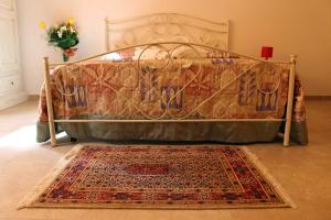 - un lit dans une chambre avec un tapis au sol dans l'établissement Le colonie, à Presicce