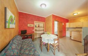 a living room with a table and a kitchen at Stunning Apartment In Porto Alabe in Magomadas +10 photos