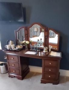 drewniane biurko z dwoma lustrami na niebieskiej ścianie w obiekcie LLys Aeron Guest House w mieście Aberaeron