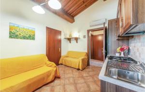 ein Wohnzimmer mit einem gelben Sofa und einer Küche in der Unterkunft Corte Ponziani 1 in Orentano