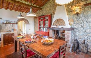 cocina con mesa de madera y chimenea de piedra en Lovely Home In Roccalbegna With House A Panoramic View, en Roccalbegna