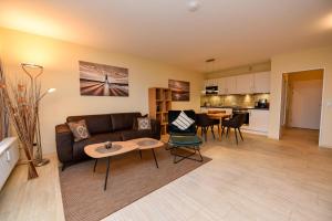 a living room with a couch and a table at Haus "Panorama" Appartement PAN068 in Duhnen