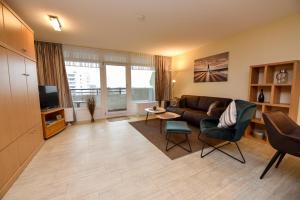 a living room with a couch and a tv at Haus "Panorama" Appartement PAN068 in Duhnen +20 photos