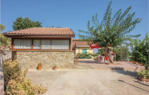 a house with a stone wall and a tree at Villa Marisa in Perdifumo
