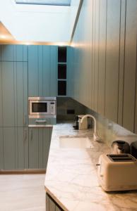 a kitchen with a sink and a microwave at Sumptuous House With Wi Fi Near The Sea in Villerville