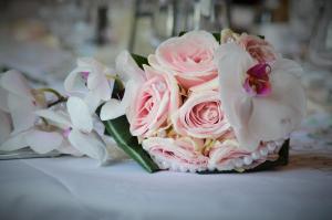 a bouquet of pink roses and orchids on a table at Hotel Indigo Rochester - Mayo Clinic Area in Rochester
