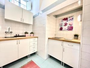 a kitchen with white cabinets and a sink at Apartments Center Castelo de São Jorge I in Lisbon