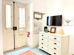 a bedroom with a dresser and a tv on a wall at Apartments Center Castelo de São Jorge I in Lisbon