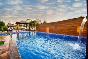 a swimming pool with a water fountain at The Majestic Villa by 23 VillaStay - Private Pool & Garden in Lonavala