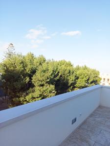 un balcon blanc avec des arbres en arrière-plan dans l'établissement Dimora Mest Clement, à Fasano