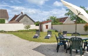 a patio with a table and chairs and an umbrella at Holiday Home Landreville Rue De Crais in Landreville