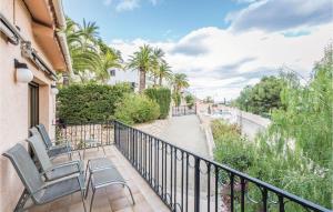 a balcony with chairs and a walkway with palm trees at 5 Bedroom Awesome Home In Altea in Altea