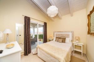 a bedroom with a bed and a large window at Bini Sole - Villa de lujo con piscina en Menorca in Binibeca