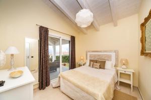 1 dormitorio con cama y ventana grande en Villa BINI SOLE, en Binibeca
