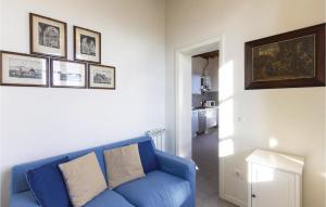a blue couch in a living room with pictures on the wall at Il Ghiro in Camaiore