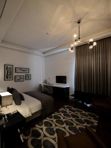 1 dormitorio con cama y escritorio. en The Nishat Hotel, en Lahore