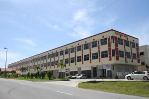 a large building with cars parked in front of it at Jeruton Hotel in Kampong Jerudong