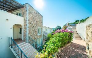 a building with stairs and flowers on the side at Trilo 6 Vm in Baja Sardinia