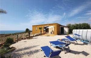 a house with blue chairs and a building at Baglio Mediterraneo in Borgo Bonsignore