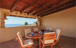 a dining room with a table and chairs and the ocean at Baglio Mediterraneo in Borgo Bonsignore