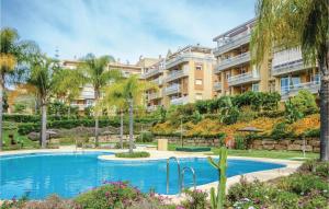 une piscine en face d'un grand immeuble dans l'établissement Amazing Apartment In Mijas Golf With House A Mountain View, à Mijas