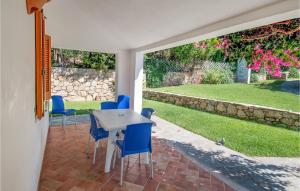 a patio with blue chairs and a white table at Trilo 6 in Budoni +5 photos