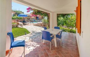 a patio with a white table and blue chairs at Trilo 6 in Budoni