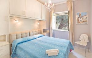 a bedroom with a blue bed and a window at Villa Anna in Capo Vaticano