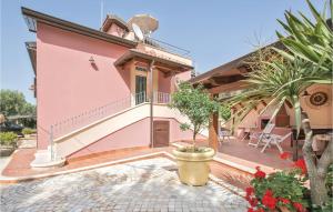 a pink house with a balcony and a patio at Villa Anna in Capo Vaticano