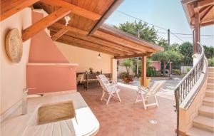 a patio with white chairs and a wooden roof at Villa Anna in Capo Vaticano +18 photos