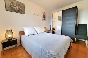 a bedroom with a large white bed and a chair at Apartment Comfort Terrace Garden Wifi in Saint-Cyr-sur-Mer