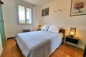 a bedroom with a bed with two lamps and a window at Apartment Comfort Terrace Garden Wifi in Saint-Cyr-sur-Mer +8 photos