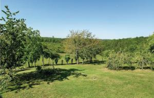 a field of grass with trees and a hill at Beautiful Home In Eyliac in Saint-Laurent-sur-Manoire +34 photos