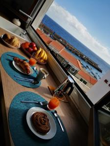 a table with a plate of food and a view of the ocean at Acogedora Vivienda Vacacional en Candelaria in Candelaria