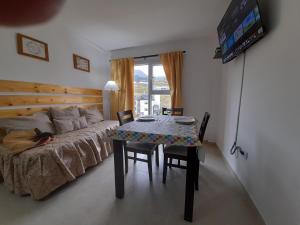 a bedroom with a bed and a table with chairs at Las Lajas in Ushuaia