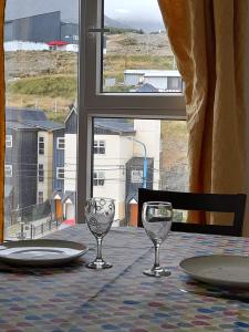 una mesa con dos copas de vino y una ventana en Las Lajas, en Ushuaia