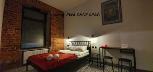 um quarto com uma cama numa parede de tijolos em Cosy Rooms em Piotrków Trybunalski