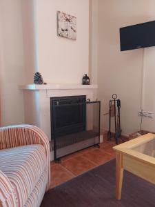 a living room with a fireplace and a couch at Apartamento Huerta Grande in Benaocaz
