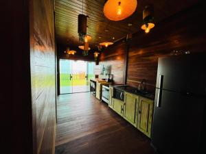 a kitchen with wooden floors and a refrigerator in a room at Chalé Rubi in Tutóia