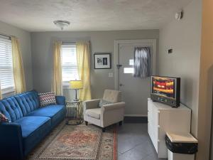 a living room with a blue couch and a tv at Modern Homestead Guest House in Reedsville