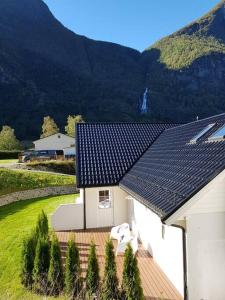 a white house with solar panels on its roof at Cheerful 4-bedroom home with fireplace, 1,5km from Flåm center in Aurland