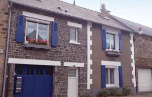a brick house with blue shutters and flowers in the window at Gorgeous Apartment In Vildé-La-Marine in Vildé la Marine