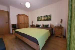 1 dormitorio con 1 cama con colcha verde en Daniela 1 by SMR Luxury Apartments, en Rauris