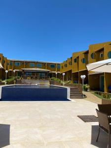 a courtyard of a building with a swimming pool at Imbassaí Summer flat Village de Luxo in Imbassai