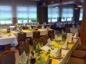a dining room with white tables and chairs at Hotel Deutsches Haus Francop in Hamburg