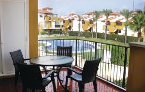Media LeguaにあるBeautiful Apartment In Vera Playa With 2 Bedrooms, Wifi And Indoor Swimming Poolのプールの景色を望むバルコニー(テーブル、椅子付)