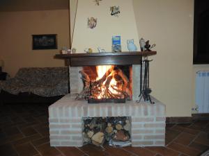 una chimenea de ladrillo en la sala de estar con chimenea en La Loggina Maxi, en Tuoro sul Trasimeno