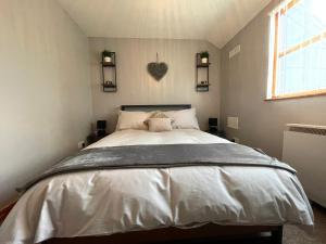 a bedroom with a large bed with a heart on the wall at Westend Holiday Let 3 Brecon in Brecon