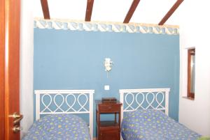 - une chambre avec 2 lits et un mur bleu dans l'établissement Vila Poiana, à Snagov