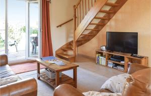 a living room with a tv and a staircase at 4 Bedroom Cozy Home In Port-en-bessin-huppain in Huppain